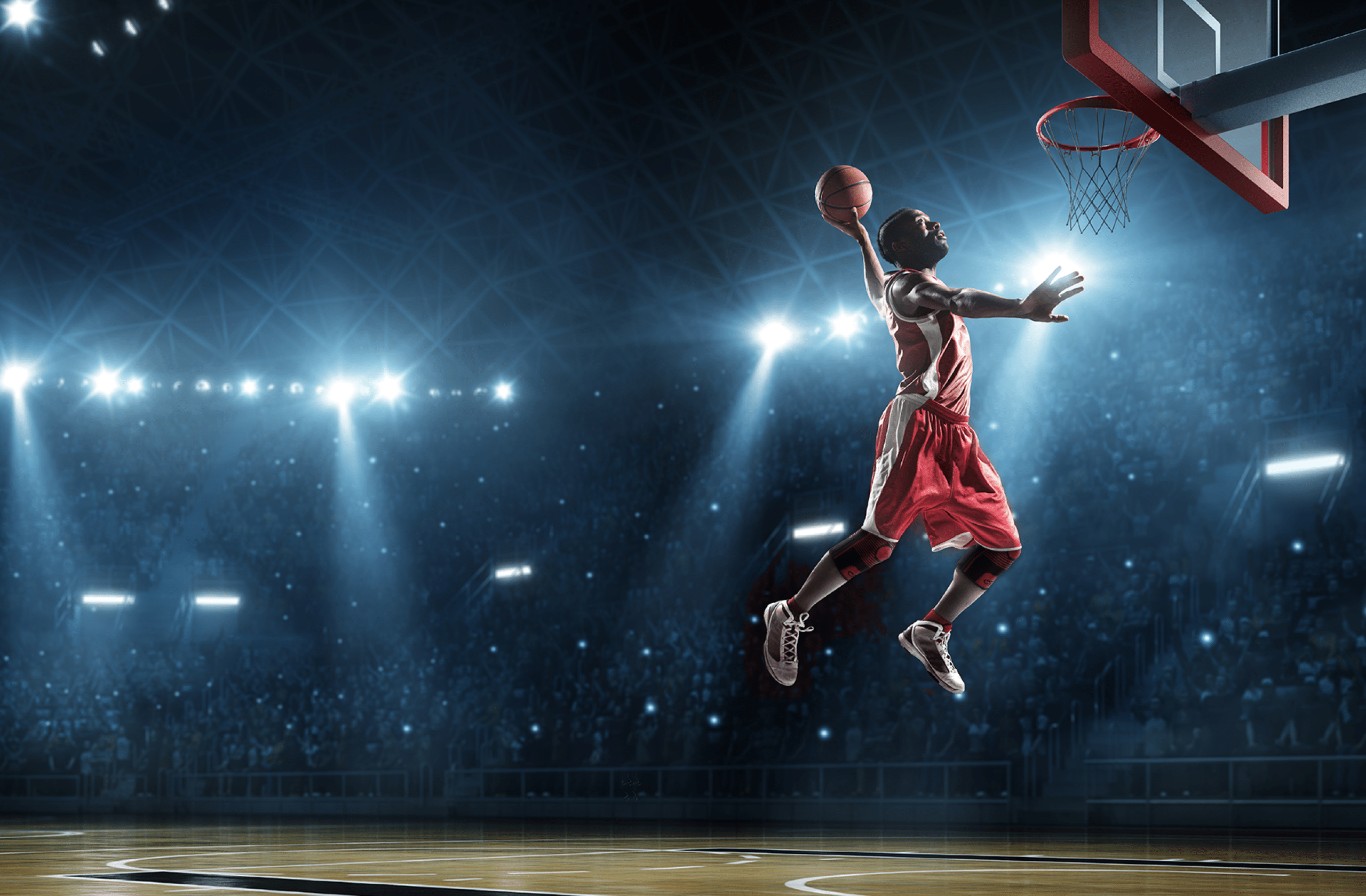 Close up image of professional basketball player about to do slam dunk during basketball game in floodlight basketball court